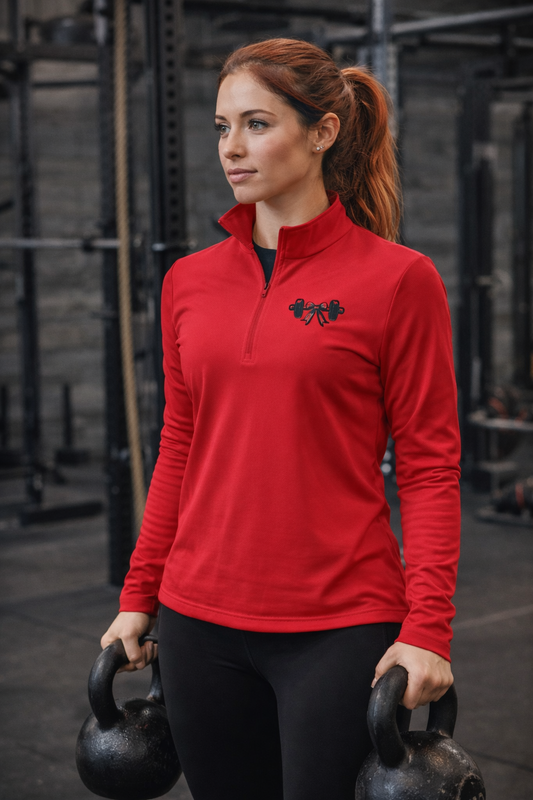 Woman in a red athletic Quarter-Zip Pullover — Small Black Barbell Heart Gym Logo holding kettlebells in a gym setting